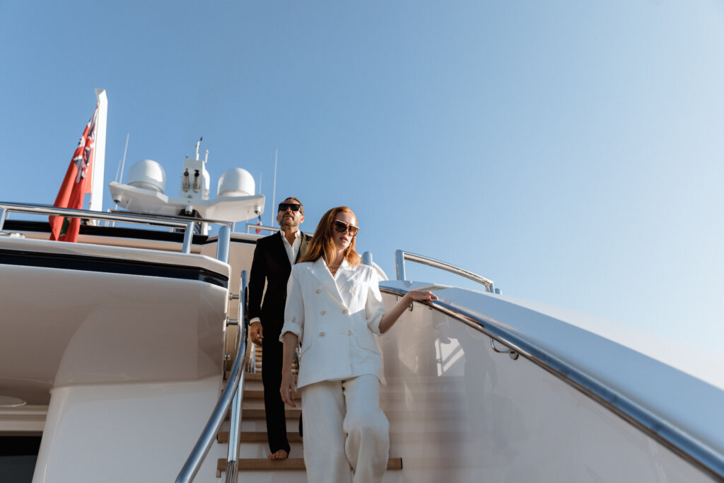 a man and woman walking up stairs on a superyacht