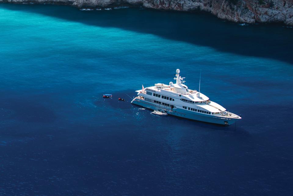A luxury charter yacht at anchor in a secluded bay