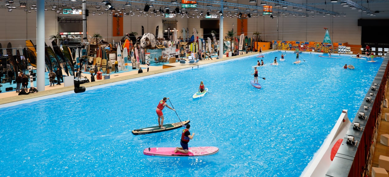 people paddle boarding in giant indoor pool at the boot Dusseldorf international boat show 