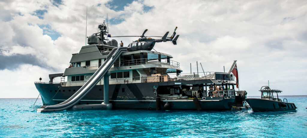 superyacht plan B at anchor with helicopter on board and inflatable slide out