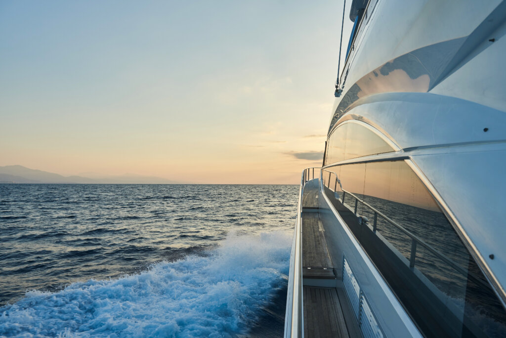A high-end yacht gliding through deep blue ocean.